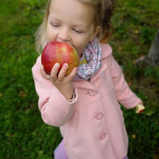 Jente som spiser eple på Lier Bygdetun